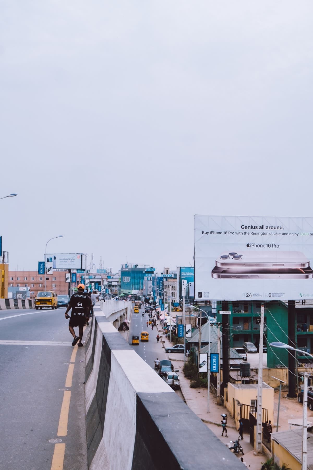 A large-format billboard over a Lagos expressway, shot from the bridge.